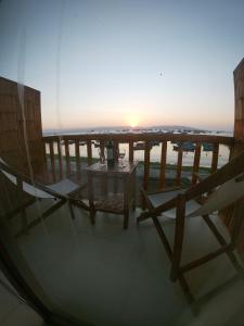 帕拉卡斯帕拉卡斯班布山林小屋的阳台上的桌椅享有日落美景