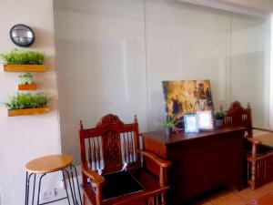 麦克坦The Runway Inn - Mactan Cebu的一间设有两把椅子和一张植物桌子的房间