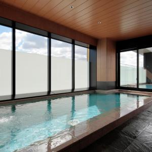 吹田Candeo Hotels Osaka Kishibe的一座带窗户的游泳池,位于一座建筑中