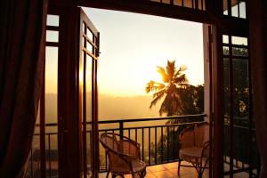 康提Serenity Hill Oasis的阳台配有椅子,享有棕榈树的景致。