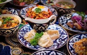 撒马尔罕YOKUB Guest House的一张带蓝白板食物的桌子