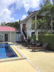 蔻立普拉图度假酒店的一个带游泳池、躺椅和房子的度假胜地