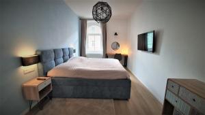 比尔森Jacob´s Apartement的一间卧室配有一张蓝色沙发的床