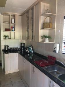 帕拉博鲁瓦Villa Danamara的厨房配有白色橱柜和黑色台面