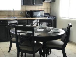 佩尼亚斯科港Apartamento Siesta Del Sol II的一间带桌椅的厨房和一间带微波炉的厨房
