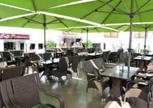 阿加迪尔蒂里拉套房酒店的一间空餐厅,配有桌椅和绿色遮阳伞
