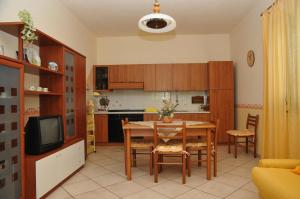 诺托玛丽娜格拉齐亚公寓的厨房以及带桌椅的用餐室。