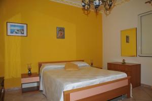 诺托玛丽娜格拉齐亚公寓的一间卧室设有一张床和黄色的墙壁