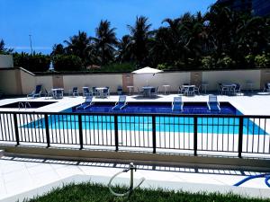 里约热内卢Marbella Apart Hotel的围栏旁带桌椅的游泳池