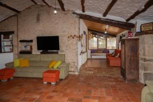 索尔索纳Casa rural Sant Grau turismo saludable y responsable的带沙发和电视的客厅