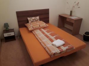德布勒森Piac utcai Apartman的一张橙色大床,带两条毛巾