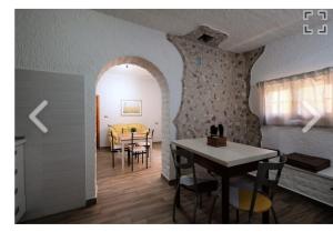 皮内托BOUGANVILLE casa vacanza的厨房以及带桌椅的用餐室。