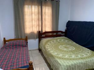 布希奥斯CASA BUZIOS PRAIA RASA的一间卧室设有两张床和窗户。
