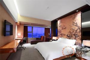 东莞东莞汇源美爵酒店的酒店客房设有一张白色大床和一张书桌