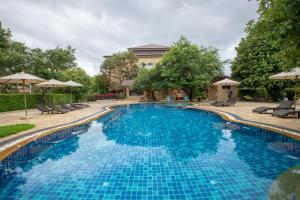 Tha Sut清莱普法瓦瑞度假酒店-SHA Extra Plus的度假村的游泳池配有椅子和遮阳伞
