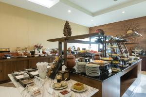 Tha Sut清莱普法瓦瑞度假酒店-SHA Extra Plus的餐厅的自助餐,包括盘子和菜肴