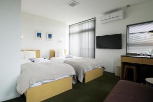 金泽萨拉拉索旅馆的酒店客房设有两张床和电视。
