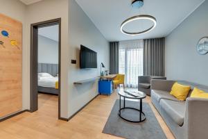 格但斯克HOTEL NUMBER ONE BY GRANO Gdańsk的带沙发的客厅和卧室