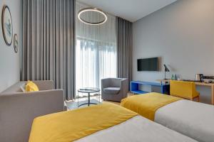 格但斯克HOTEL NUMBER ONE BY GRANO Gdańsk的酒店客房,配有两张床和椅子