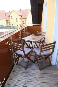 SulzfeldFerienwohnung Memmel的阳台上的木桌和椅子