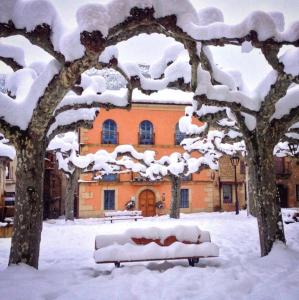 奥尼亚Camino Condal的大楼前的雪覆盖的长凳