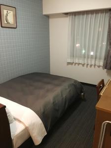 松本Garden Hotel Matsumoto的一间带床的卧室,位于带窗户的房间内