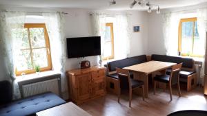 ArbesbachFerienhaus Buxbaum的客厅配有桌子和电视