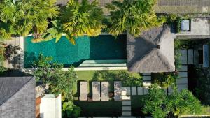 塞米亚克Villa Suar Drupadi的享有棕榈树游泳池的顶部景致