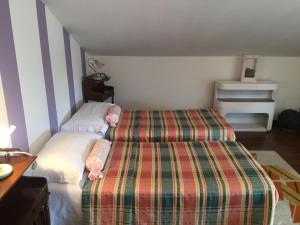 卡斯塔诺兰泽卡德尼斯酒店的一间设有两张床的卧室,位于带条纹的房间