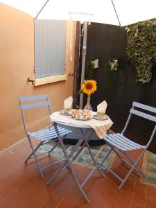 摩德纳La casa del Centro的一张桌子、两把椅子和一个带向日葵的花瓶