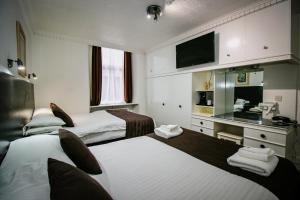 格拉斯哥Charing Cross Hotel的酒店客房设有两张床和电视。