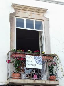 塔维拉Bea's Bed & Breakfast的阳台的窗户上有一个百叶窗和一个标志