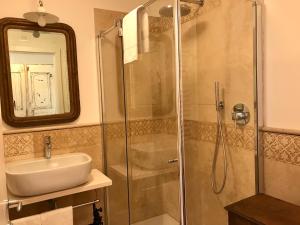 罗韦雷托画家之家酒店的带淋浴、盥洗盆和镜子的浴室