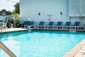 圣奥古斯丁The Flagler Inn - Saint Augustine的大楼内带蓝色椅子的游泳池
