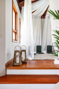 弗洛里亚诺波利斯Casa Paradisíaca na Lagoa da Conceição的一间设有两把椅子和白色窗帘的房间
