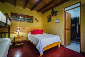 曼克拉马库拉琪姆巴斯简易别墅的一间卧室配有红色枕头的床