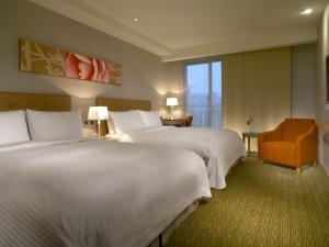 花莲市经典假日饭店的酒店客房,配有两张床和椅子