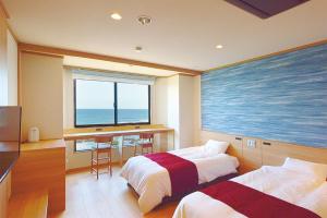 大洗町Oarai Hotel Annex Gyoraian的酒店客房设有两张床,享有海景。