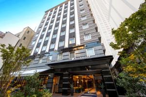 大阪Quintessa Hotel Osaka Shinsaibashi Comic & Books的建筑物前部的 ⁇ 染