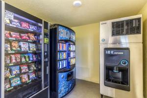 西棕榈滩Quality Inn Palm Beach International Airport的冰箱旁的自动售货机出售饮品