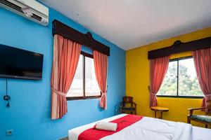 茂物RedDoorz near Istana Bogor的一间卧室设有一张床和两个窗户。