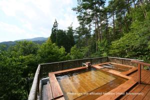 南木曾町东光味噌日式旅馆的树林甲板上的热水浴池