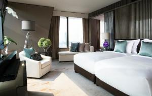 曼谷曼谷大倉新頤酒店的酒店客房,设有两张床和一张沙发