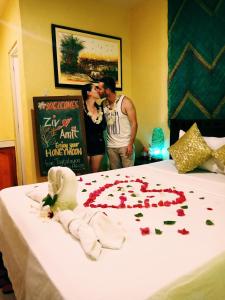 锡基霍尔泰格巴莱恩山林小屋旅馆的一对夫妇在床上吻玫瑰