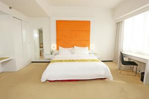 斗湖Borneo Royale Hotel的卧室配有一张白色大床和一张书桌