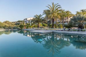 Pau玛斯拉珠莉酒店的一座棕榈树游泳池和一座建筑