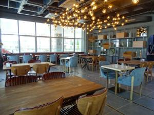 伊斯坦布尔Teknosports Otel的餐厅设有木桌、椅子和窗户。