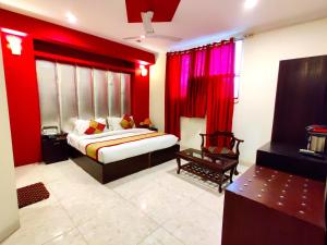 新德里Hotel Unistar的卧室设有红色的墙壁、一张床和椅子