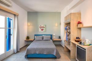 菲罗斯特法尼阿弗罗蒂特酒店的一间卧室设有蓝色的床和窗户。