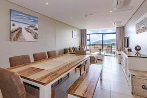 巴利托Suite 501, Zimbali Suites的用餐室配有大型木桌和椅子